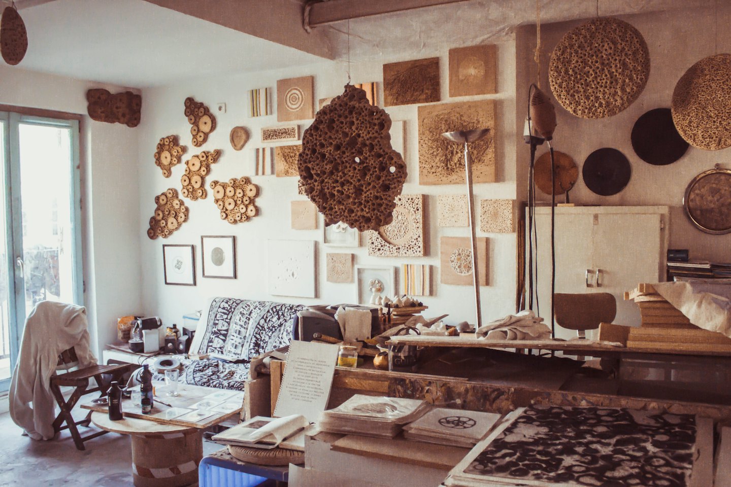 Artist workshop filled with sculptures and crafting supplies.