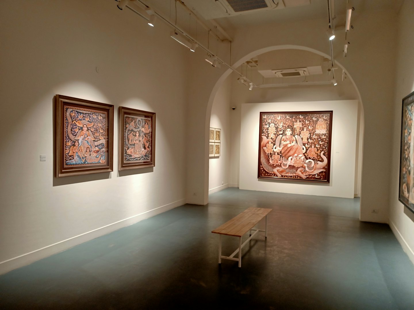 Wooden bench sits in a modern white art gallery.
